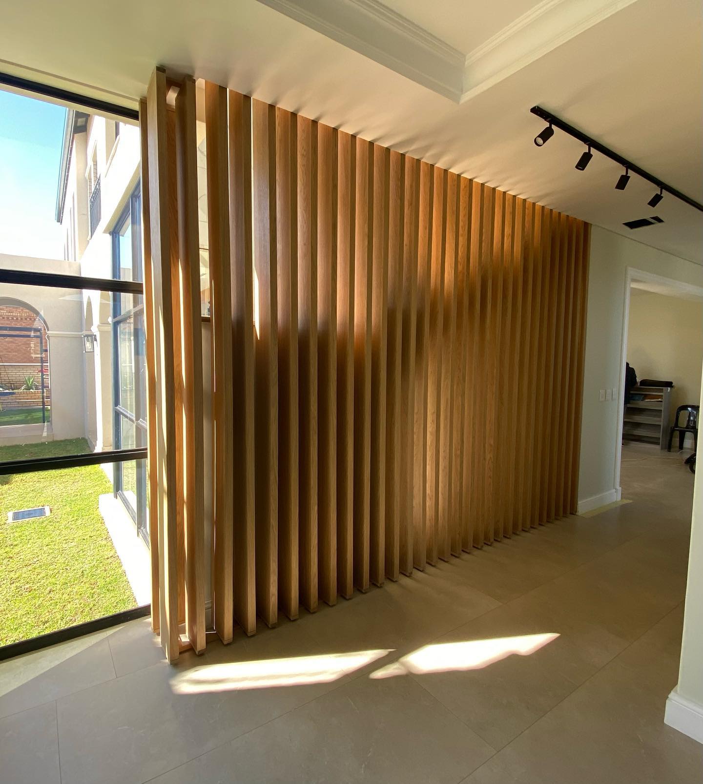 Tall corner timber slat feature wall in an exterior courtyard